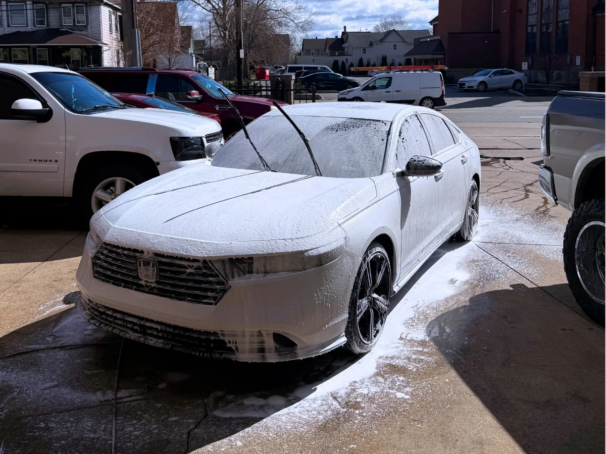 White Honda Accord covered in foam during a hand wash in a Cleveland driveway